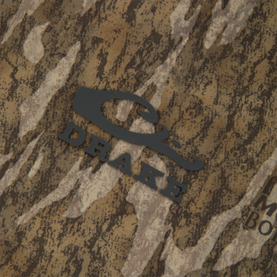 Close-up of RTL - El Poncho's camouflage fabric with black vinyl lettering, highlighting its robust, waterproof design for outdoor hunting and weather protection.