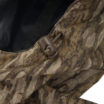 Close-up of RTL - El Poncho's camouflage fabric with a drawcord and cord-lock, highlighting its waterproof, durable design for versatile outdoor protection.