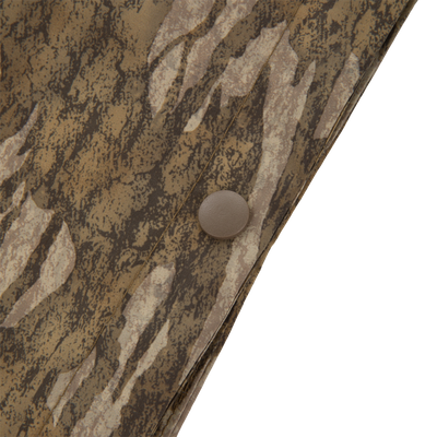 Close-up of RTL - El Poncho's camouflage fabric, showing a snap button and stitching, highlighting the durable, waterproof design ideal for hunting and outdoor adventures.