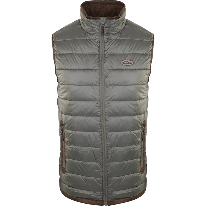 A silver-colored durable Synthetic Double Down Vest by Drake Waterfowl, featuring a horizontal baffle design, suede accents, and reverse coil zippers for outdoor warmth and style.