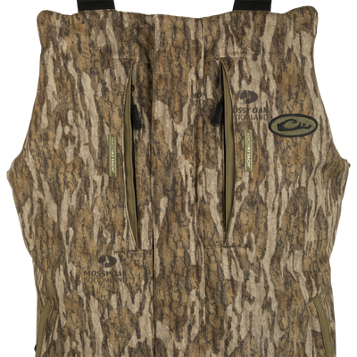 LST Reflex Insulated Bib: Waterproof, windproof vest with tree and camouflage patterns. Close-ups of fabric, logo, and sign. Rugged durability and performance for hunting and fishing.