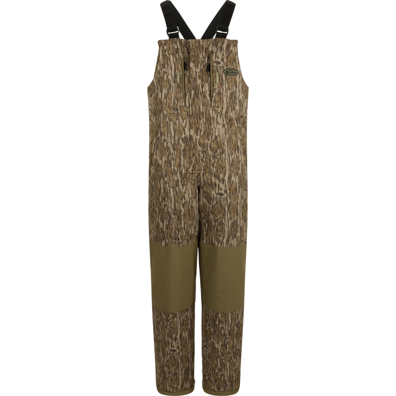 LST Reflex Insulated Bib with camouflage print, reinforced olive-green knees, zippered chest pockets, and adjustable suspenders, ideal for hunting and outdoor durability.