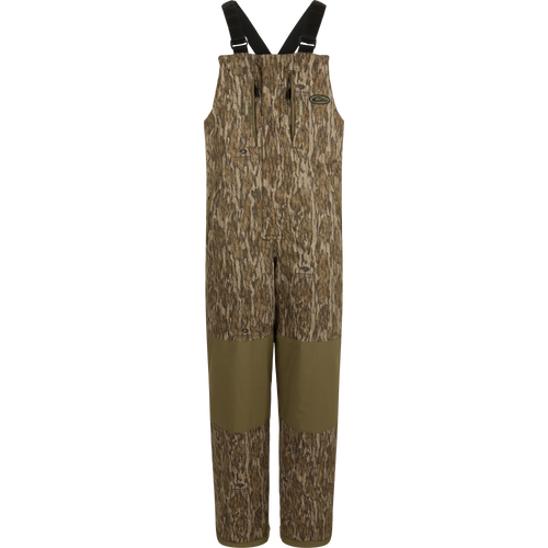 LST Reflex Insulated Bib with camouflage print, reinforced olive-green knees, zippered chest pockets, and adjustable suspenders, ideal for hunting and outdoor durability.