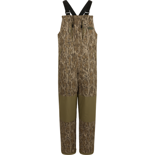 LST Reflex Insulated Bib with camouflage print, reinforced olive-green knees, zippered chest pockets, and adjustable suspenders, ideal for hunting and outdoor durability.