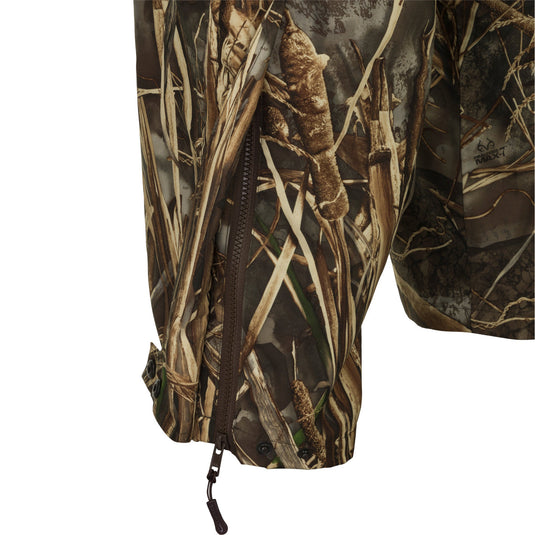 A close-up of the EST Waterproof Over Pant, a camouflage pant designed for hunters needing waterproof protection. Cut generously to wear over base layers, jeans, or other pants. Features elastic waist, zippered pockets, and ankle-to-knee zippers for easy on/off. Made with 100% waterproof/windproof/breathable Refuge HS fabric. Perfect for outdoor activities.