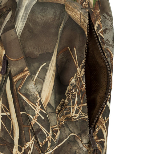 A close-up of the EST Waterproof Over Pant, a brown outdoor pant with an elastic waist, zippered pockets, and ankle-to-knee zippers for easy on/off. Made of 100% waterproof Refuge HS fabric with HyperShield 2.0 Technology. Designed for hunters seeking total waterproof protection.