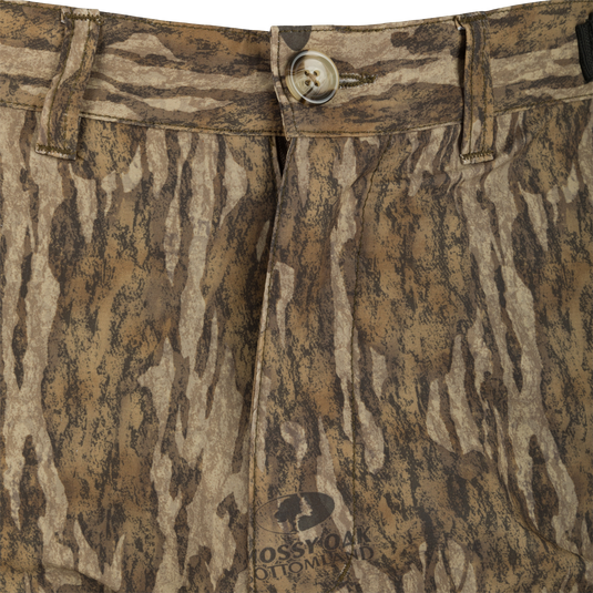 A close-up of the EST Camo Tech Stretch Pant - Realtree. Made from lightweight polyester, it offers breathability and a comfortable fit for hunting. Features include adjustable waistband, multiple pockets, and elastic ankle cinch cord.