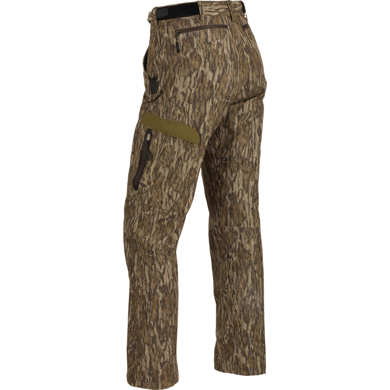 A pair of lightweight, versatile Youth EST Camo Stretch Tech Pants made from 100% polyester. Features include adjustable hook & loop waistband, multiple pockets, zippered fly, and elastic ankle cinch cord. Perfect for hunting and outdoor activities.
