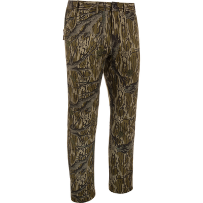 MST Ultimate Wader Pants in woodland camo, showcasing cargo style with adjustable ankles, ideal for hunting; features include zippered pockets and articulated knees for mobility.