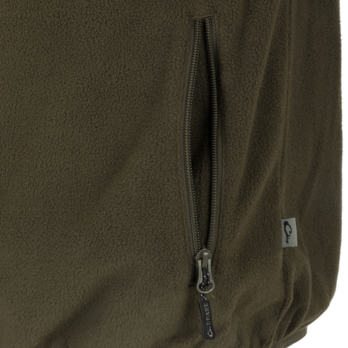 Camp Fleece Vest: Close-up of a zipper on a jacket, featuring a black and silver zipper pull. Perfect for layering under Drake outerwear.
