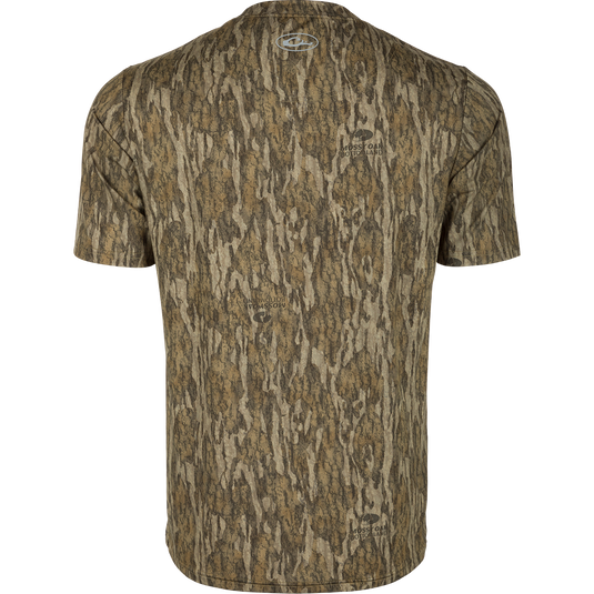 Youth EST Camo Performance Short Sleeve Crew - Realtree shirt with logo close-up. 92% Polyester/8% Spandex fabric offers 4-Way Stretch and Shield 4 Sun™ UPF 50+ Treatment, Shield 4 Coolant™ Treatment, Shield 4 Odor™ Treatment, and Shield 4 Stains™ Treatment for outdoor activities.