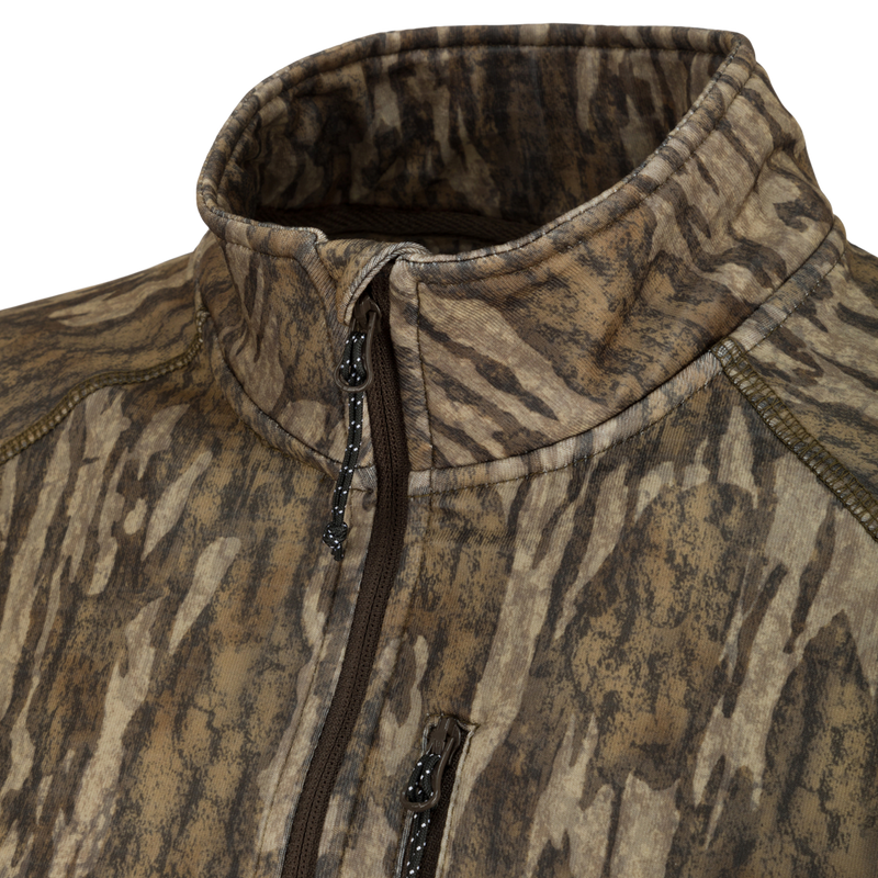 Women's MST Breathelite 1/4 Zip Camo Pullover - A close-up of a jacket with a zipper and fabric surface. Stay warm and stylish with this fleece pullover featuring raglan sleeves and a vertical zippered chest pocket.
