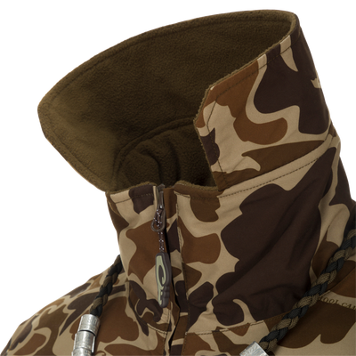 MST Waterproof Fleece-Lined Quarter Zip Jacket close-up showing camouflage pattern, high fleece-lined collar, partially unzipped zipper, braided drawcord, and metal cord locks.