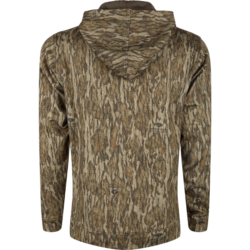 MST Performance Hoodie - Realtree: A close-up of a camouflage shirt with a logo on a stone surface. Tags: clothing, fabric.