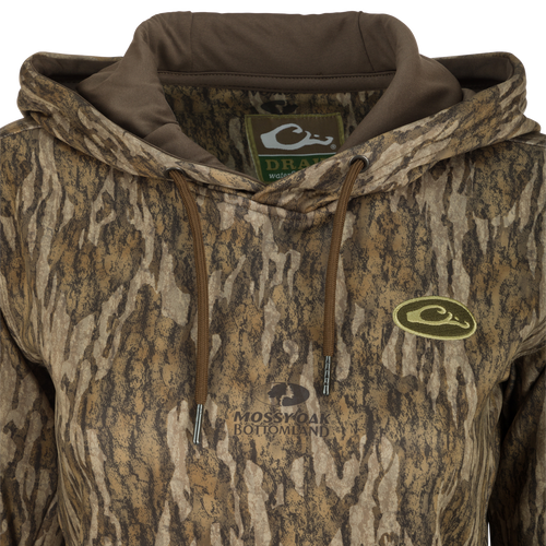 Women's MST Performance Hoodie - Realtree: A close-up of a jacket with a logo. Combed fleece interior for comfort and heat retention. Double-lined hood for wind protection. Kangaroo pouch for extra warmth. Improved stretch and fit for increased range-of-motion.