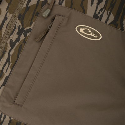 Close-up of a Sale MST Waterproof Full Zip Jacket w/ Hood in camouflage, featuring a brown chest pocket with a zippered closure and an embroidered logo.