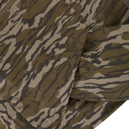 Close-up of a Sale MST Waterproof Full Zip Jacket w/ Hood featuring a zippered, windproof design in a brown and tan camouflage pattern with printed brand logos.