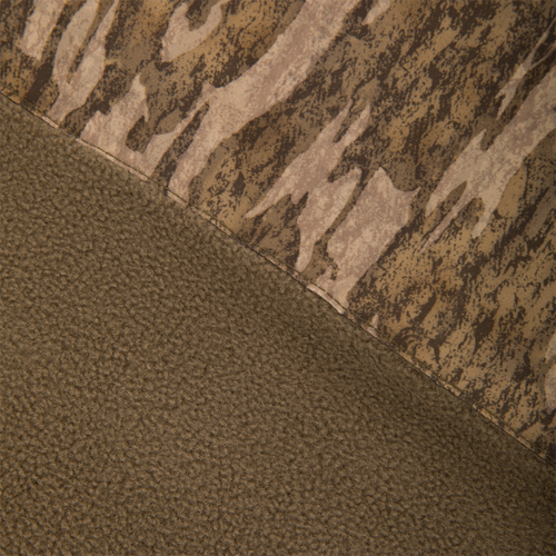 Close-up of the MST Youth Eqwader Quarter Zip Jacket, showcasing camo fabric and olive-brown fleece, highlighting Drake Waterfowl's innovative fabric technology for optimal comfort in harsh conditions.