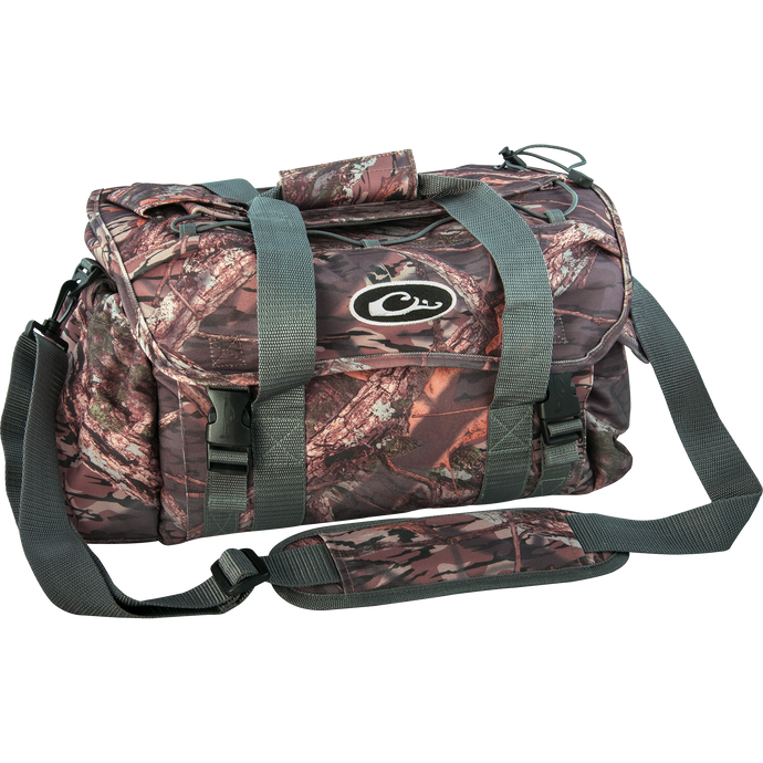A large camouflage bag with straps, featuring 18 pockets for organizing gear. Waterproof internal compartment and durable HD2™ material. Perfect for hunting and outdoor activities.