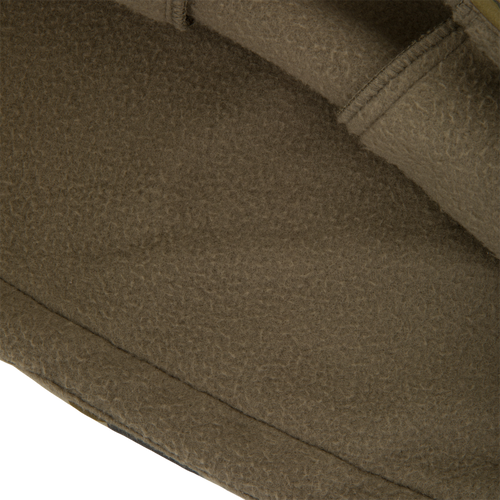 Close-up of olive-brown fleece fabric with seams, part of the BFCM - MST Camo Eqwader 1/4 Zip Jacket, showcasing patented waterfowl clothing technology.