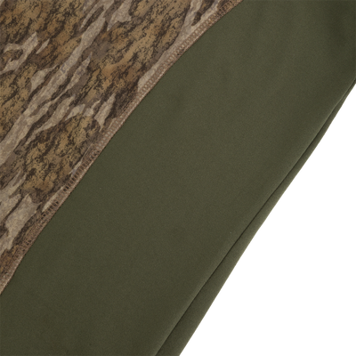 Close-up of a Drake Base Layer Crew Neck featuring a brown camouflage pattern on the upper section and solid olive green fabric on the lower section.