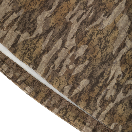 Close-up of the moisture-wicking hem on a brown and tan camouflage Drake Base Layer Crew Neck.