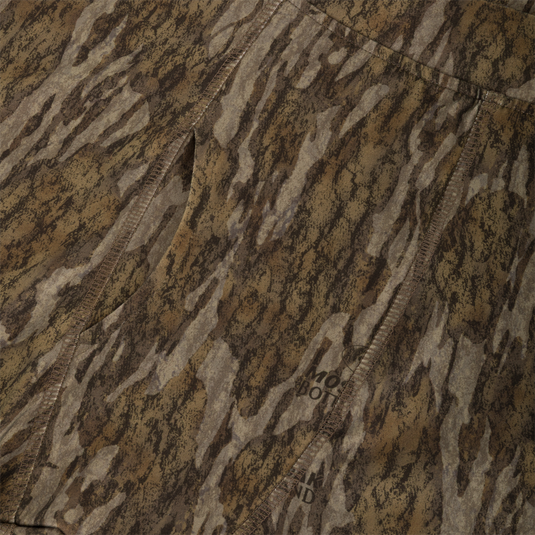 Close-up of moisture-wicking, brown and tan camouflage Drake Base Layer Bottom featuring a vertical seam and a faint Waterfowl brand logo imprint.