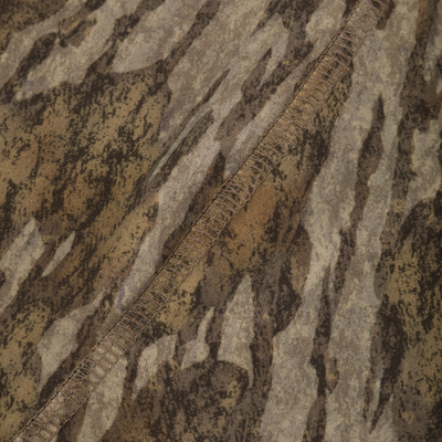 Close-up of a Drake Base Layer Bottom in a brown and tan camouflage pattern, showing a moisture-wicking fabric and a visible seam.