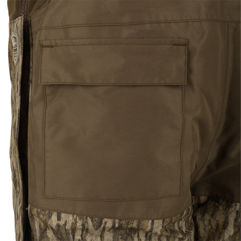 LST Guardian Elite Bibs: A close-up of a khaki military uniform pocket on the Drake Waterfowl bib. Made with waterproof Refuge HS Fabric and reinforced knees.
