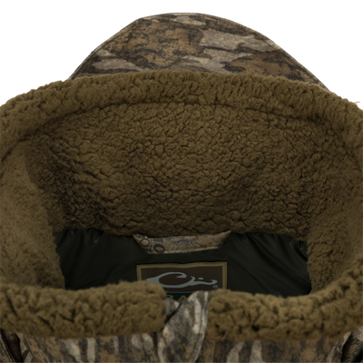 Close-up of the Guardian Elite™ LST Insulated Timber Jacket, showcasing the durable fabric, reinforced stitching, and logo detail, designed for waterfowl hunting.