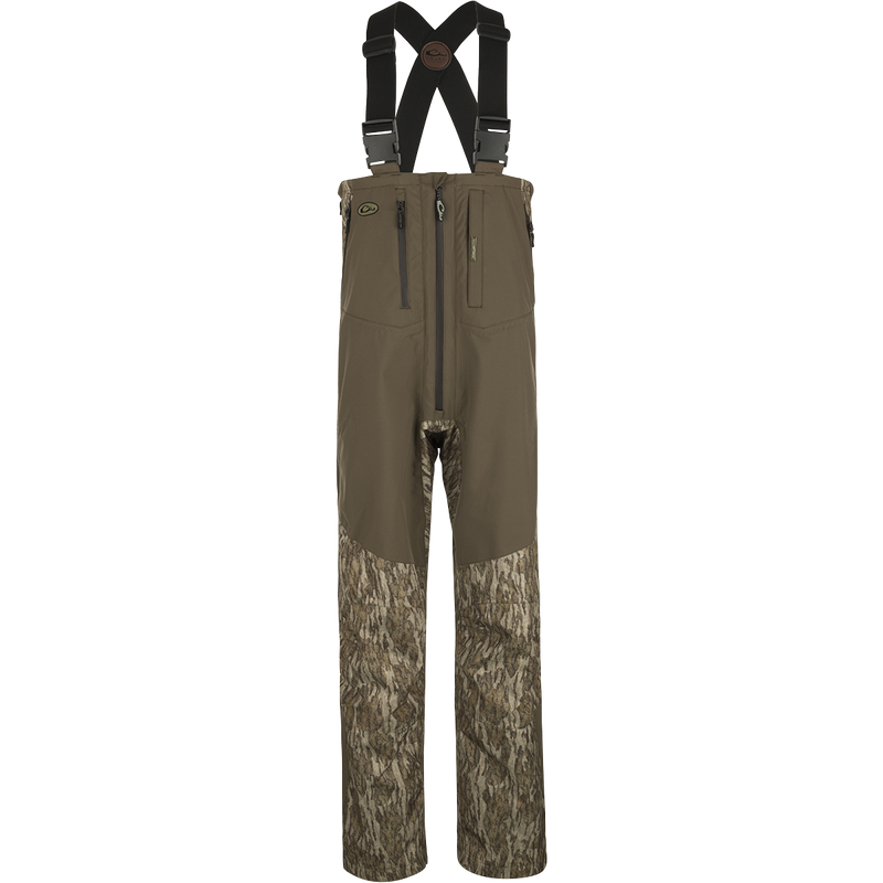 A pair of lightweight, waterproof bibs from Drake Waterfowl's EST Guardian Elite Pro Ultralight 3-Layer Bibs collection. These bibs offer all-day comfort and protection from the elements. Featuring multiple pockets for storage and full-length waterproof zippered legs for easy wear over boots. Perfect for waterfowl hunting and outdoor activities.