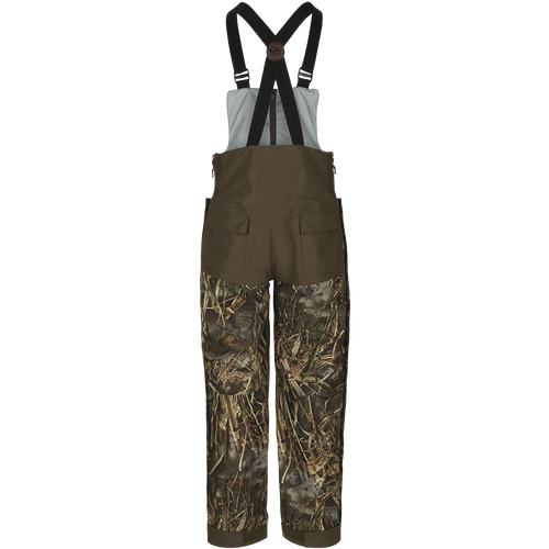 A product image of the EST Guardian Elite™ Bib Shell Weight, perfect for hunters needing protection from the elements. The Guardian Elite™ Bib Shell Weight offers full-body cover-up with waterproof/windproof/breathable fabric. Featuring reinforced knees, adjustable shoulder straps, and multiple pockets.