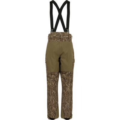 MST Waist-High Insulated Bibs with suspenders, featuring water-resistant zippers, cargo pockets, and reinforced knees, designed for optimal warmth and mobility in hunting conditions.
