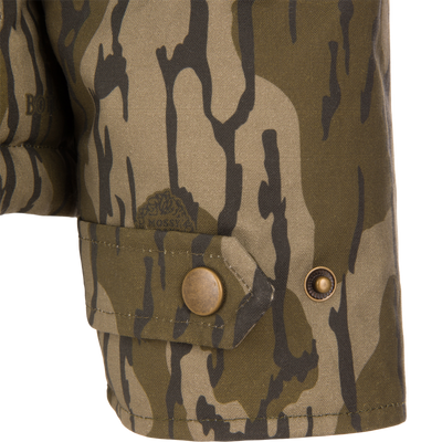Close-up of a buttoned cuff tab on the sleeve of a LST Insulated Waxed Cotton Jacket in camouflage.