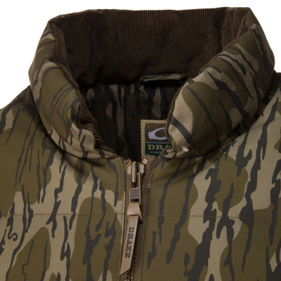 Close-up of a Waterfowl LST Insulated Waxed Cotton Jacket, featuring a camouflage-patterned, featherless design with a brown corduroy collar and a zippered front.