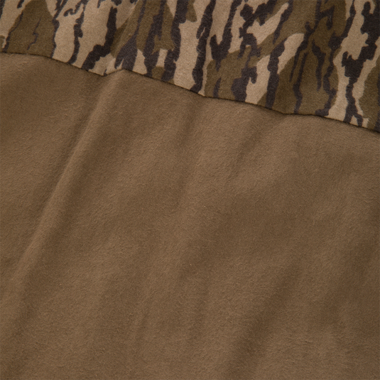 A closeup of the LST Insulated Waxed Cotton Jacket featuring a brown solid lower section and a camouflage patterned upper section.