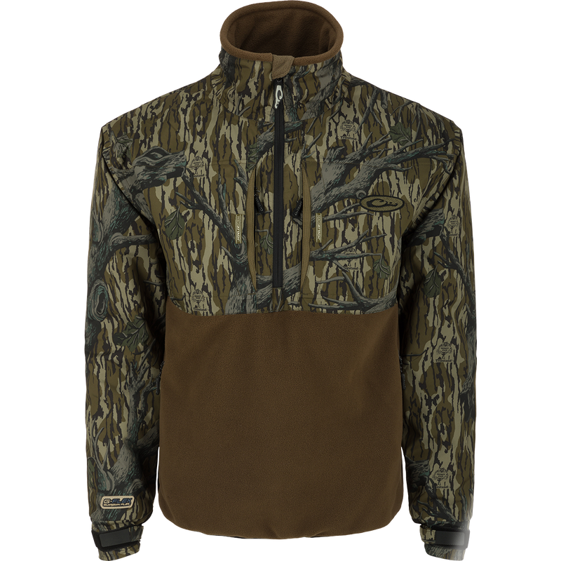 MST Guardian Eqwader Flex Fleece 1/4 Zip Jacket, a waterproof and breathable camouflage jacket with fleece lower body for enhanced breathability under waders. Features elbow and forearm protection, adjustable cuff closures, and multiple pockets for convenience. Ideal for outdoor activities.