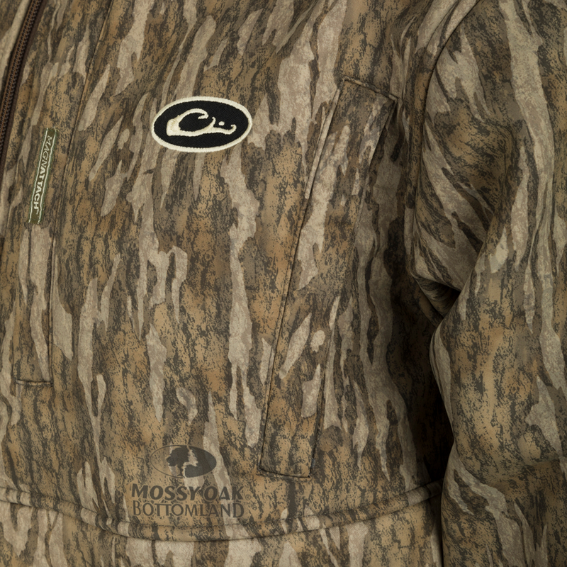 MST Hole Shot Windproof Eqwader 1/4 Zip Jacket - Realtree: A close-up of the jacket with a black and white logo, offering superior protection and temperature control for any weather. Sherpa-lined, windproof upper body and breathable lower body. Features high handwarmer pockets and adjustable waist.