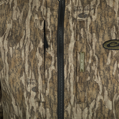 Drake MST Windproof Softshell Jacket in Mossy Oak camo, featuring Magnattach™ chest pockets, heavy-duty zipper, and branded details for hunting enthusiasts.