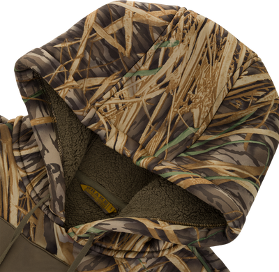 Close-up of a Slacker Wader Pocket Hoodie featuring a camouflage pattern and a fuzzy, olive-colored polyester fleece interior lining.