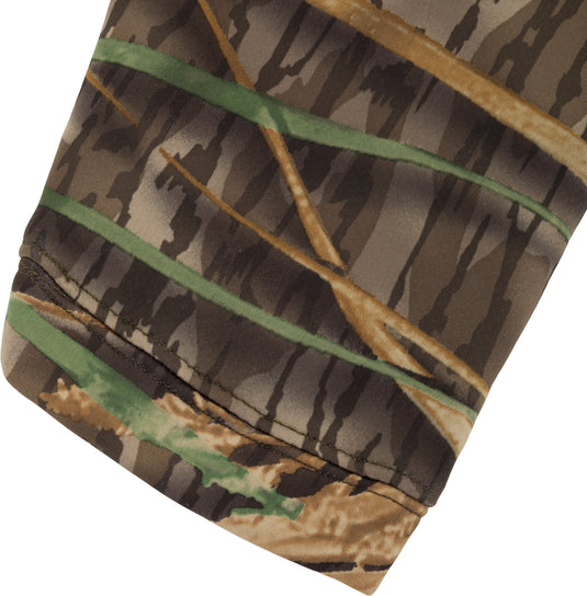 Close-up of a Slacker Quarter Zip Hoodie sleeve with a forest camouflage pattern and a stitched hem.