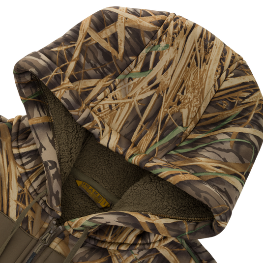 Waterfowl Slacker Quarter Zip Hoodie with High Handwarmer Pockets in a camouflage grass pattern featuring a fleece-lined hood.