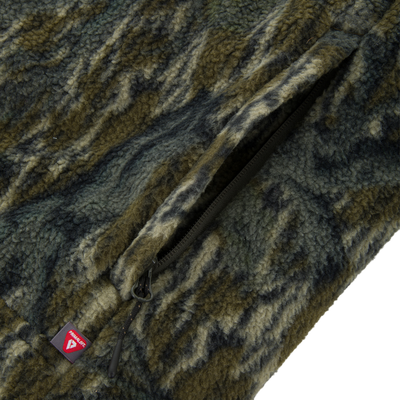 Close-up of Non-Typical Statix Sherpa Fleece Insulated Vest, showcasing textured camo-style fleece, zipper, and Primaloft label, designed for warmth and mobility in hunting.