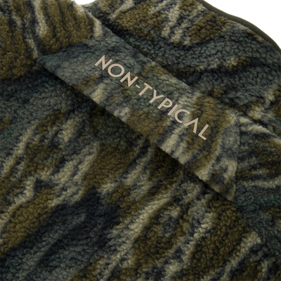 Close-up of the Non-Typical Statix Sherpa Fleece Insulated Vest, showcasing woolly fabric and NON-TYPICAL print, designed for warmth and mobility in hunting conditions.