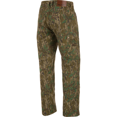 Throwback 80 Field Pant featuring camouflage design, durable cotton twill, reinforced knees, and antique brass riveted pockets, ideal for hunting and outdoor activities.