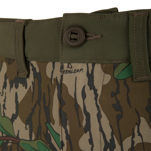 Close-up of Ol' Tom Tech Stretch Turkey Pants, highlighting camouflage pattern, button detail, and breathable mesh pockets for hunting flexibility.