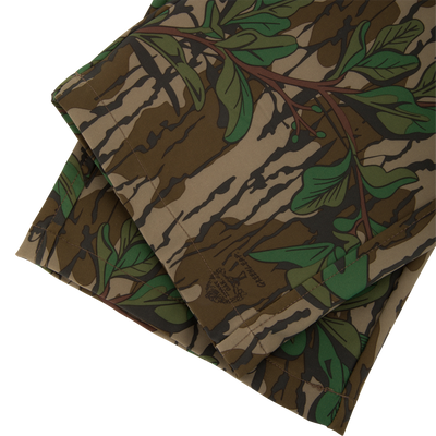 Ol' Tom Tech Stretch Turkey Pants with camouflage pattern, showcasing folded fabric designed for flexibility and comfort, featuring cargo pockets and breathable mesh areas.
