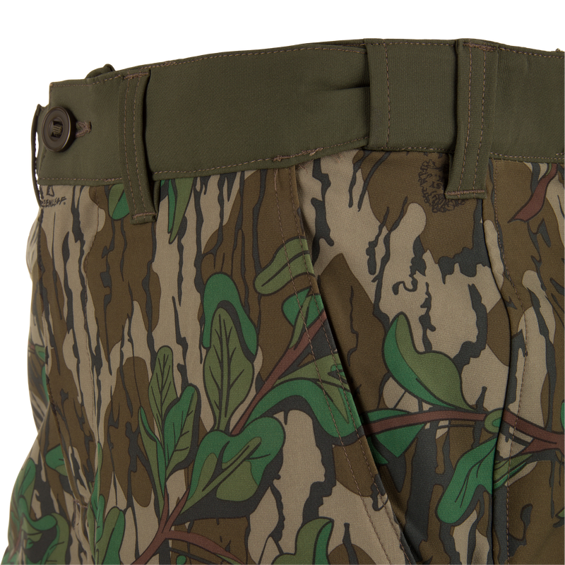 Close-up of Ol' Tom Tech Stretch Turkey Pants highlighting camouflage pattern, snap-closure cargo pockets, and breathable mesh details for flexible hunting comfort.
