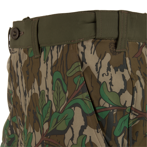 Close-up of Ol' Tom Tech Stretch Turkey Pants highlighting camouflage pattern, snap-closure cargo pockets, and breathable mesh details for flexible hunting comfort.