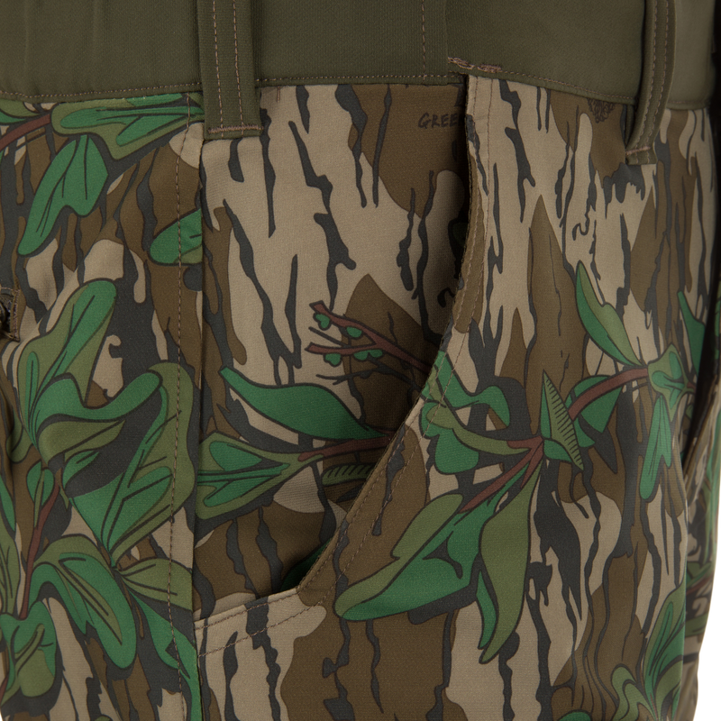 Close-up of Ol' Tom Tech Stretch Turkey Pants, showcasing camouflage pattern and durable, flexible fabric with functional cargo pockets and articulated knee panels for hunting.